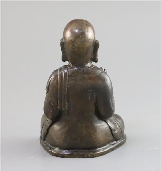 A Chinese bronze figure of a seated Luohan, 17th/18th century, H. 16cm